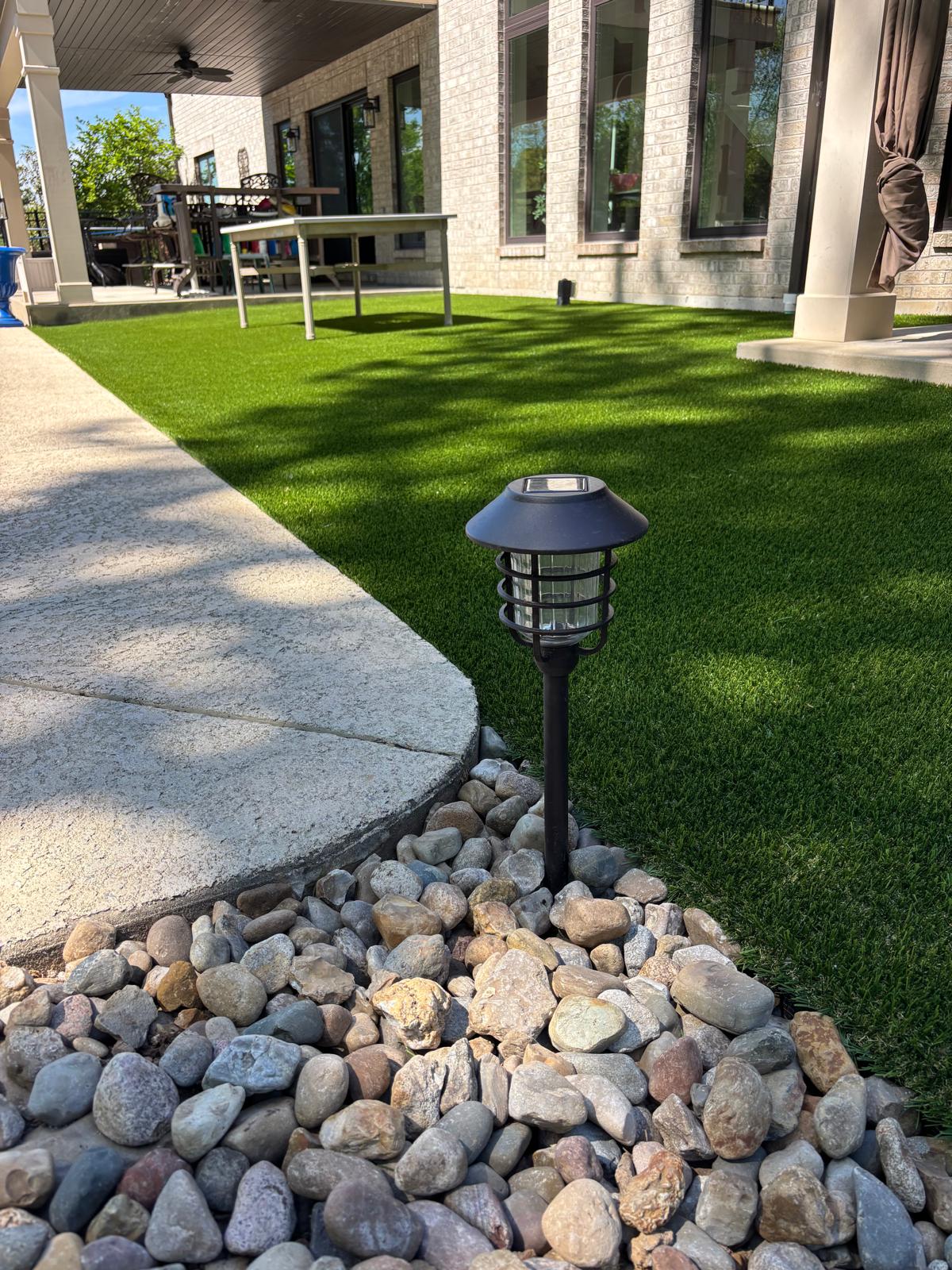 Finished synthetic turf lawn near patio walkway